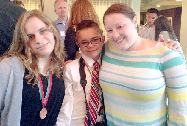 Special Olympics athletes Isabelle Williams (left) and Nathaniel Nelson pose with Kristen Pingel