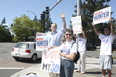 King County executive candidate Ross Hunter waves a sign along with his mother and campaign staffers at Bellevue Crossroads Mall on Primary Day.