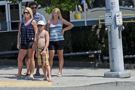 Pedestrians wait at a crosswalk in downtown Bellevue on Wednesday.