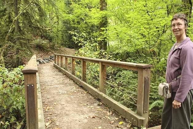 Peggy Price stands near a footbridge constructed by the city of Newcastle along the May Creek Trail.