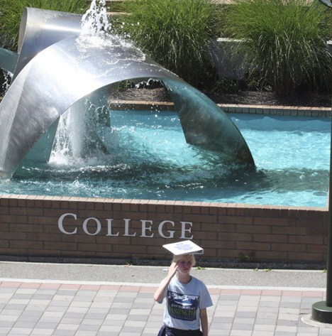 A member of the advocacy group Environment Washington improvises a sun shield while soliciting new members at the Bellevue College commons.