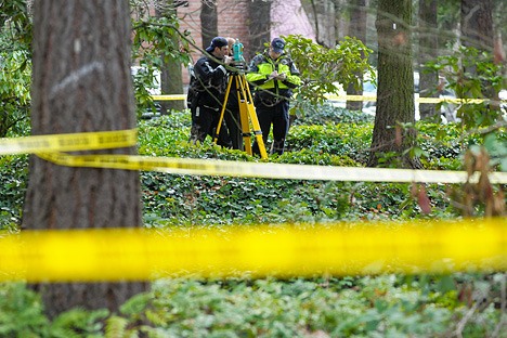 Redmond Police investigators survey the scene after a body was found in an ivy-filled median near an office building at 15446 Bel-Red Road on Wednesday afternoon. The police have labeled the death 'suspicious'