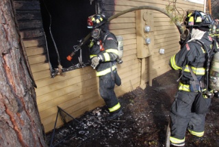 Firefighters work to douse a fire at an apartment complex early Monday morning