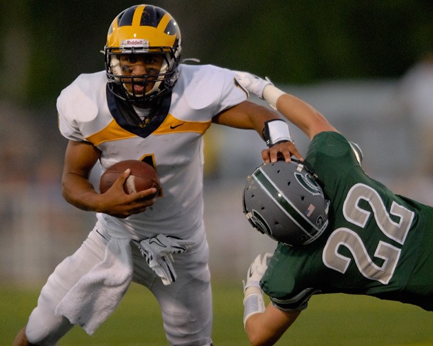 Wolverine QB Tyler Hasty (1) stiff arms Spartan DB Connor Gilchrist (22) during the first half at Skyline High School in Sammamish on Friday. Bellevue won 31-17.