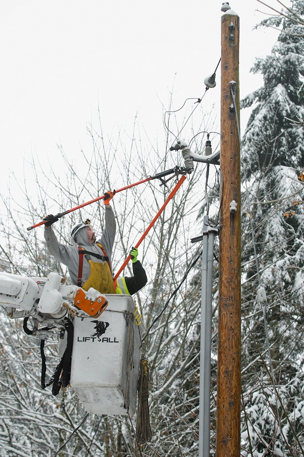 A crew works to restore power to homes near 143rd Avenue NE and Bel-Red Road in Bellevue on Friday morning. Residents in the area had been without electricity since about 2 p.m. on Thursday.