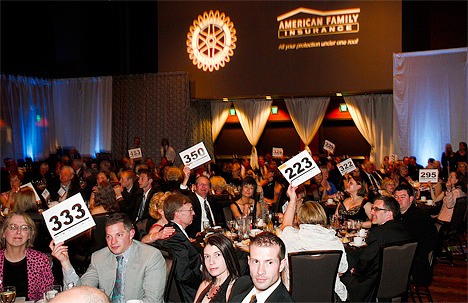 Guests at the Bellevue Rotary Club annual auction show their paddles to raise $100