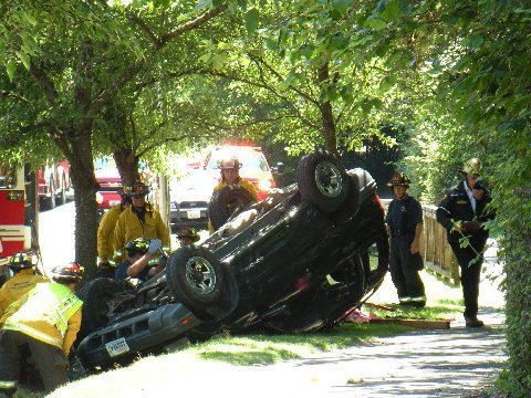 Emergency crews work on an SUV that overturned near a ditch on the 16200 block of SE Phantom Way Sunday afternoon. The driver