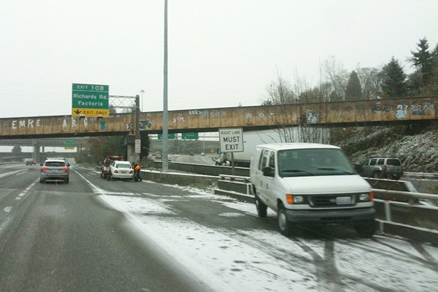 A vehicle is towed from the scene of an accident near the Richards Road exit on Eastbound Interestate 90 as the snow continued to fall in Bellevue on Monday morning.