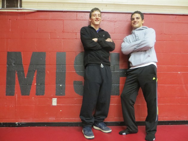 Kyle Kasner (left) and Tomas Narvaja have helped coach Joel Reese turn around the Totems wrestling program.