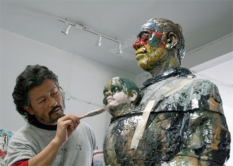 Wanxin Zhang works on one of his massive ceramic figures.