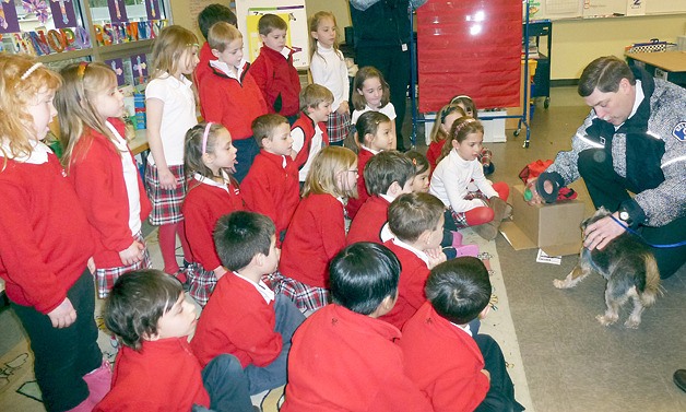 Capt. Chuck Heitz of the Bellevue Fire Department shows students at St. Louise Parish School how a pet resuscitation kit works.