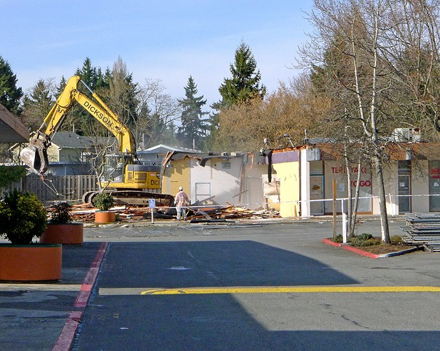 Crews demolish part of the Lake Hills Shopping Center on Monday as part of redevelopment of the facility. The center