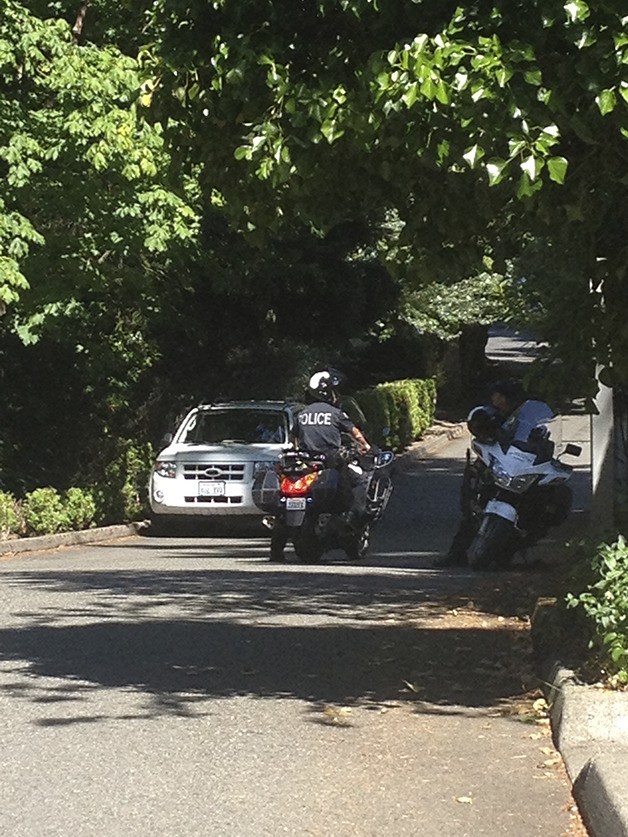 Two Bellevue Police officers talk near the entrance to a condominium development where a woman was found dead.