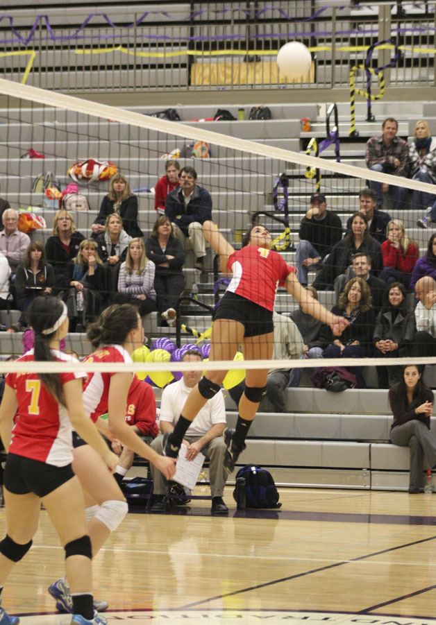 Abby Seethoff (12) and Emmy Freed (7) look on as Kelsey Davila smashes one of her eight kills during the Knights' win over Issaquah that clinched the league title.