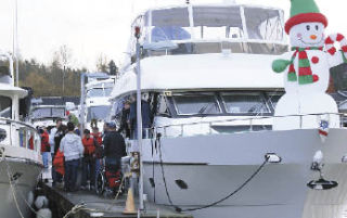 Yacht club members help passengers on to one of the boats that will take them on a 1- to 2-hour cruise around Lake Washington.