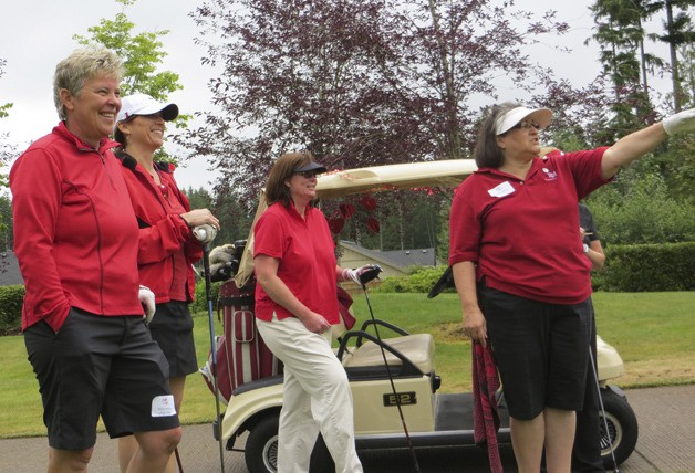 Molly Miller (far left) shares a laugh with a group of players at the 18th hole at The Golf Club at Redmond Ridge during this year's Golf Fore Red event to support women's heart health.