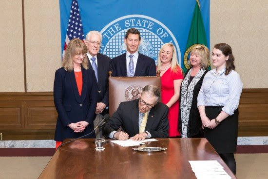 Rep. Patty Kuderer (D-Clyde Hill) looks on as Gov. Jay Inslee signs HB 2425. Photo courtesy of Washington LSS