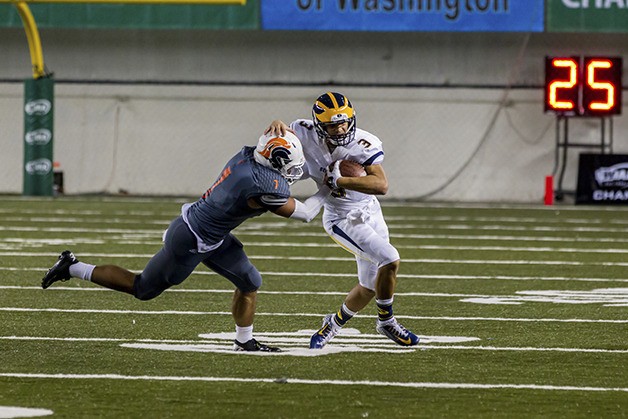 Bellevue quarterback Justus Rogers tries to escape the grasp of Eastside Catholic defensive player Brandon Wellington during the 2014 Class 3A state championship game at the Tacoma Dome. Photo courtesy of Mike Centioli/Centioli Photography